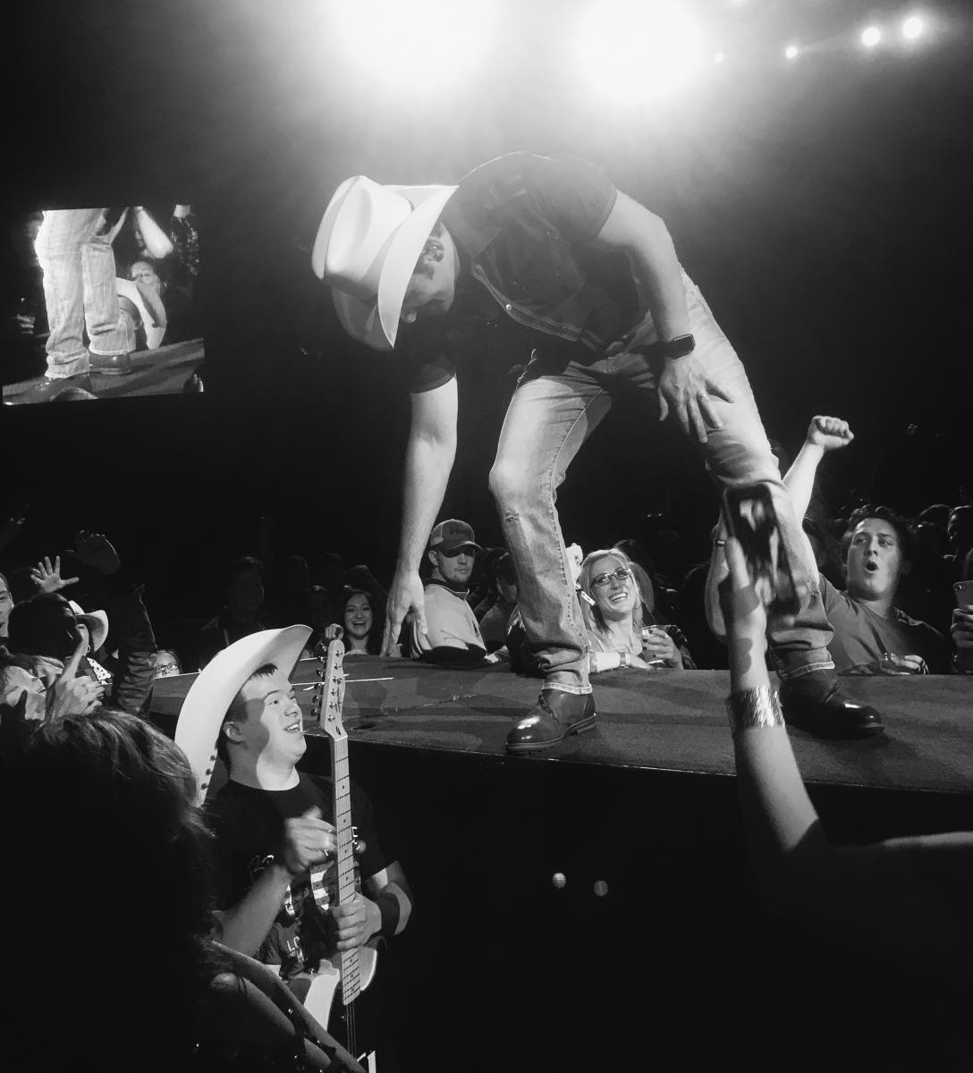 Brad Paisley gifts a guitar to a young man with Down's Syndrome to the roaring delight of the crowd.